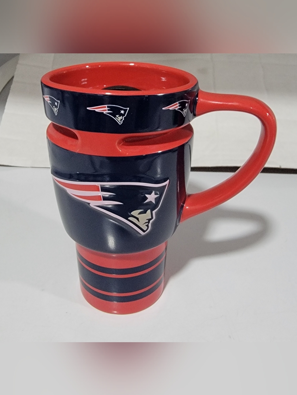 New England Patriots travel mug. Red and navy blue, has team logo and 'Patriots'